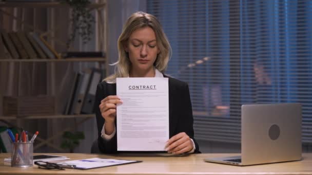 Zakenvrouw houdt contract in haar handen en knijpt in de zijne. Vrouw in zakenpak zit aan tafel. Opzegging contract, afwijzing werkdocument, rip deal. Slow motion klaar, 4K bij 59,94fps. — Stockvideo