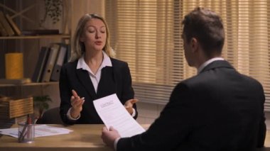 Ortaklar sözleşme şartlarını tartışıyor. Adam belgelere bakar ve imzasını atar. Kadın, ofis toplantısındaki sözleşmeyi sonuçlandıran adamla el sıkışıyor. Yavaş çekim hazır, 4K 59.94fps 'de..