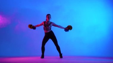 Pembe ışıkla aydınlatılmış, ellerinde ponpon kızlar olan sevimli amigo kızlar tarafından gerçekleştirilen enerjik tezahürat dansı. Amigoluk, tezahürat yapan spor takımı. Yavaş çekim.