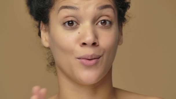 Portrait de beauté de jeune femme afro-américaine rapportant et racontant beaucoup d'informations intéressantes. Modèle féminin noir posant sur fond de studio brun. Ferme là. Prêt au ralenti, 4K à 59.94fps. — Video