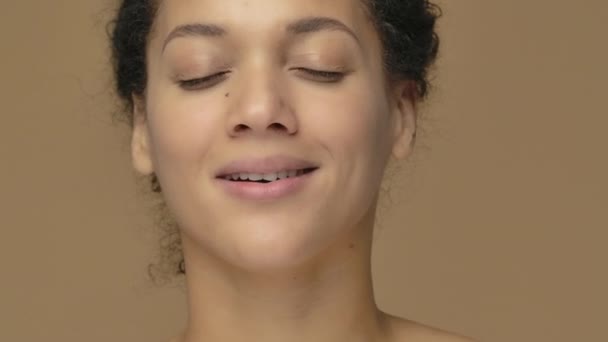 Szépség portré fiatal afro-amerikai nő pihentető, csukott szemmel, megnyugodva és mélyen lélegzik. Fekete nő pózol barna stúdió háttérben. Közelről. Lassú mozgás kész, 4K 59.94fps-on.. — Stock videók