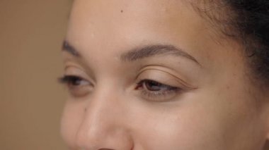 Kahverengi kadın gözleri ciddi ciddi yana bakıyor. Doğal güzelliği olan Afro-Amerikan kadın gözleri. Mükemmel temiz ve pürüzsüz ciltli makro portreyi kapat. Yavaş çekim hazır, 4K 59.94fps 'de..