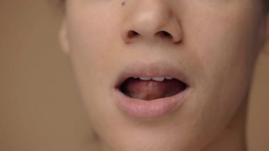 Afrika kökenli Amerikalı bir kadının makro portresi dudaklarını diliyle yalıyor ve alt dudağını dişleriyle ısırıyor. Doğal güzelliği olan siyah bir kadın yüzü. Yavaş çekim hazır, 4K 59.94fps 'de..