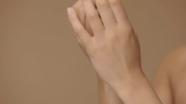 Ellerine cilt kremi süren Afrikalı Amerikalı bir kadın. Karışık ırktan kadın elinin makro portresini kapat, parmaklarıyla krem sür. Yavaş çekim hazır, 4K 59.94fps 'de..