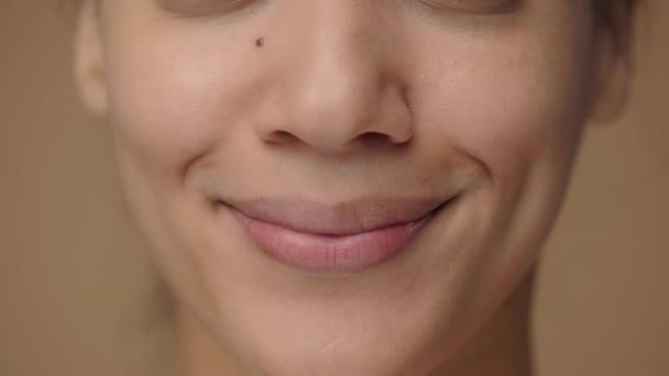 Hermosos labios femeninos sonriendo revelando dientes blancos. Rostro de mujer afroamericana con belleza natural. Primer plano macro retrato con la piel limpia y lisa perfecta. Cámara lenta lista, 4K a 59.94fps. — Vídeos de Stock