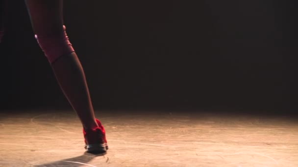 Pembe şortlu güzel bir kadın dans ediyor ve parlak ışıklarla dans ediyor. Seksi bir dansçının silüeti kalçalarını sallayarak baştan çıkarıcı vücudunu gösteriyor. Kapat.. — Stok video