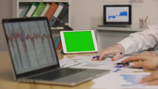Pria dan wanita melihat kertas dengan grafik, menggunakan laptop. Analisis strategi pemasaran, perdagangan saham. Tablet dengan kunci kroma layar hijau. Tutup. Gerakan lambat siap, 4K di 59.94fps. — Stok Video