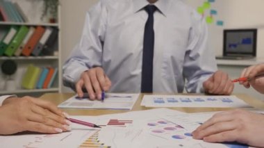 Lider ve iş ortakları belgeleri çizelgeler ve grafiklerle analiz ederler. Şirket yönetim kurulu toplantısında borsa ticaretiyle ilgili bir proje hakkında brifing, tartışma. Kapatın. Yavaş çekim hazır, 4K 59.94fps 'de.