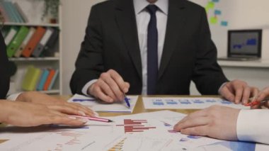 Lider ve iş ortakları belgeleri çizelgeler ve grafiklerle analiz ederler. Şirket yönetim kurulu toplantısında borsa ticaretiyle ilgili bir proje hakkında brifing, tartışma. Kapatın. Yavaş çekim hazır, 4K 59.94fps 'de.
