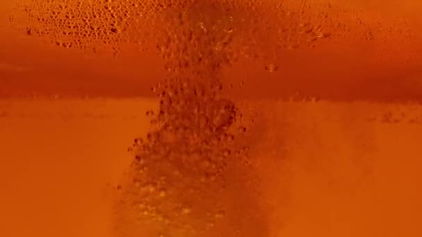 啤酒泡沫宏观。近处是一杯淡淡的啤酒.黄金液体倒入玻璃杯中，造成许多气泡、波浪和漩涡。新鲜工艺啤酒酒精饮料。慢动作. — 图库视频影像