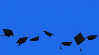 Mavi ekran arka planlı stüdyoda yavaş çekimde yayınlanan mezuniyet şapkaları.