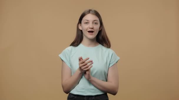 Retrato de modelo de beleza encantador batendo palmas com wow alegria feliz e prazer. Menina em t-shirt branca posando no fundo do estúdio marrom. Fecha. Movimento lento pronto 59.94fps. — Vídeo de Stock