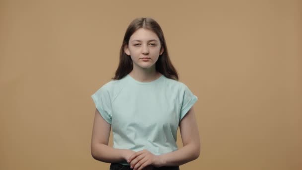 Portrait of charming beauty model looking at the camera with a wow surprised and shocked expression. Young girl in white t-shirt posing on brown studio background. Close up. Slow motion ready 59.94fps — Stock Video