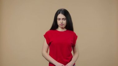 Doğal güzelliği olan modelin portresi negatif bir şekilde başını sallıyor, işaret parmağını sallayarak masum olduğunu gösteriyor. Genç esmer kız kahverengi stüdyo arka planında poz veriyor. Kapatın. Yavaş çekim hazır 59.94fps
