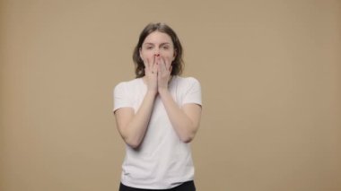 Doğal güzelliği olan bir modelin portresi aklına bir fikir geldiği için mutludur. Kahverengi stüdyo geçmişinde kıvırcık saçlı genç kız poz veriyor. Kapatın. Yavaş çekim hazır 59.94fps.