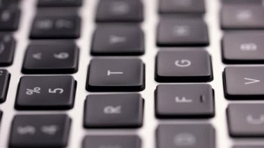 Laptop klavyesinin makro görüntüsü. Klavye boyunca kamera hareketi, bazı tuşlar bulanık. Ağır çekim. Kapat..