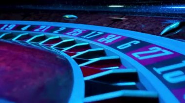 Dönen rulet çarkı yanıp sönen neon ışıklarının ışınlarında kapanıyor. Küçük beyaz top siyah 35 'e vurdu, bahis kazandı. Rulet tekerleğinin bir kısmı ağır çekimde çalışır..