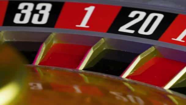 Une roue de roulette de casino avec une boule blanche sur vert 0. Table de jeu de casino, chiffres rapprochés. Une partie de la roulette tourne au ralenti. — Video