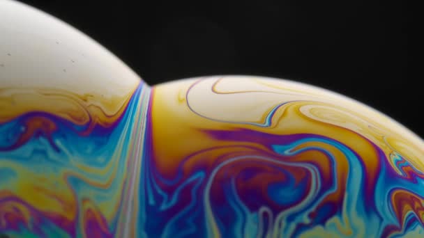 Savon bulle macro couleurs arc-en-ciel créant des motifs multicolores. Bulle de savon en mousse colorée au ralenti. Très similaire aux autres planètes de la galaxie. Gros plan. — Video