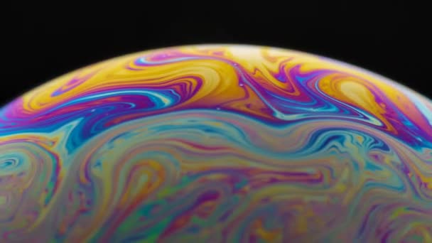 Planète psychédélique abstraite de bulle de savon sur fond noir. Réfraction lumineuse sur une bulle de savon, vacro fermer les particules en mouvement. Couleurs arc-en-ciel sur fond noir. Mouvement lent. — Video