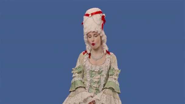 Portrait de courtisane en dentelle vintage blanche robe et perruque est gomme à mâcher et bulles soufflantes. Jeune femme posant en studio avec fond bleu. Ferme là. Ralenti prêt 59.94fps. — Video