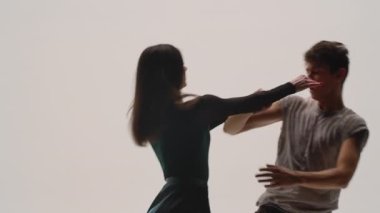 Modern koreografinin unsurları, beyaz stüdyo arka planında birkaç dansçı tarafından icra edilen çağdaş şarkılar. Erkek ve kadın tutkuyla dans eder, duygularını dansta ifade ederler. Ağır çekim. Kapat..