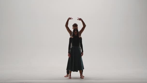 Eléments de chorégraphie moderne, contemporaine interprétée par un jeune couple de danseurs sur fond de studio blanc. L'homme et la femme dansent passionnément, exprimant leurs sentiments dans une danse. Mouvement lent. — Video