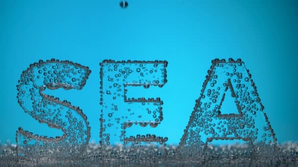 Η λέξη θάλασσα υποβρύχια σε φυσαλίδες οξυγόνου σε μπλε φόντο. — Αρχείο Βίντεο