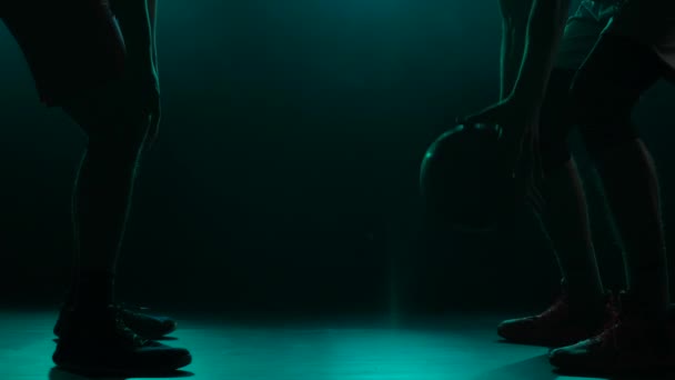 The throw-in of the ball before the start of the game in basketball competition. Two opposing players jumping for possession of the ball. Silhouette. Slow motion. — Stock Video