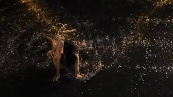 Emotional dramatic contemporary in rain performed by wet, half naked dancer. Silhouette of woman lying on water surface and creating splashes. Passion, emotions, feelings. Top view. Slow motion. — Stock Video