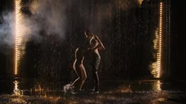 Bir çift genç dansçı, yağmurun altında tutkuyla çağdaş dans ediyorlar. Erkek ve kadın duygularını dansla ifade ederler. Karanlık, su, sprey, tutku. Yavaş çekim.
