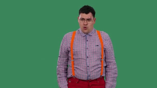 Překvapený muž přikývne a řekne ne, ne, ne. Portrét muže v brýlích, kostkovaná košile s oranžovými podvazky ve studiu na zelené obrazovce. Zpomal. Zavřít. — Stock video