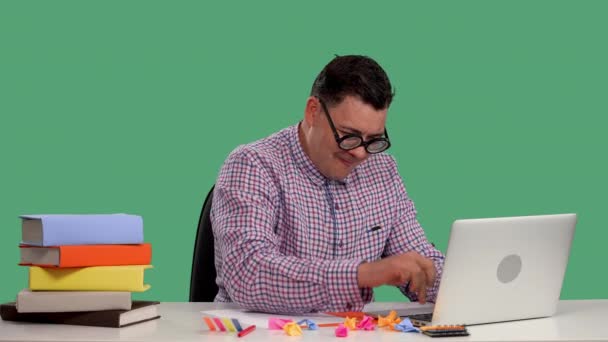 Un hombre se sienta en una mesa, usa una computadora portátil, apaga una computadora, se regocija, celebra una victoria, hurra, el trabajo ha terminado. Retrato de un hombre en el estudio en una pantalla verde. En cámara lenta. De cerca.. — Vídeos de Stock