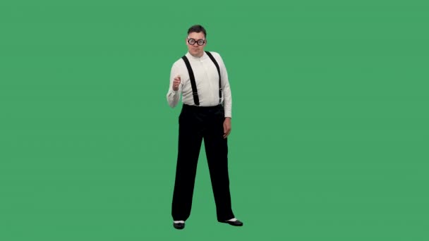 O homem está dançando a dança do robô. Retrato de um homem em uma camisa branca com suspensórios e óculos com lentes grossas no estúdio em uma tela verde. Movimento lento. — Vídeo de Stock