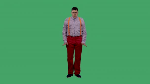 De verbaasd man knikt met zijn hoofd en zegt nee, nee, nee. Portret van een man in een bril, een geruit shirt met oranje bretels in de studio op een groen scherm. Langzame beweging. — Stockvideo