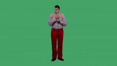 Ağlayan ve avucunda gözyaşı toplayan bir adamın portresi. Gözlüklü, ekose gömlekli, turuncu askılı yeşil ekranlı bir adam. Yavaş çekim.