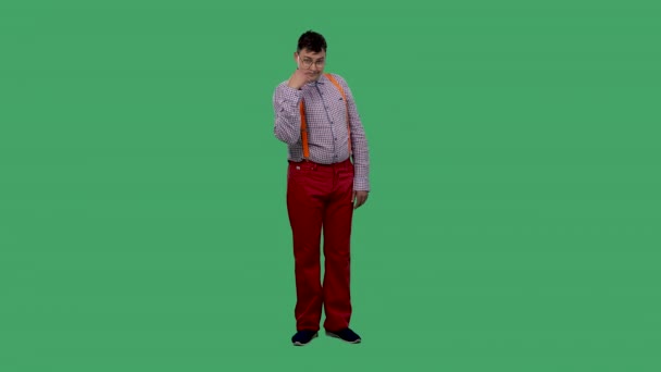 Caucasian man makes the gesture I am watching you, pointing two V-sign fingers at eyes. Portrait of a man in glasses, in a shirt with orange suspenders in the studio on a green screen. Slow motion. — Stock Video