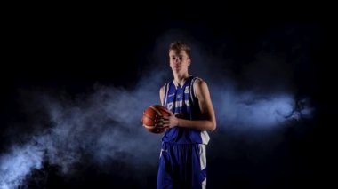 Genç bir basketbolcu topla servis yapıyor. Karanlık, dumanlı bir stüdyoda, spot ışıkları altında yarışmadan önce antrenman yapan bir adam. Ağır çekim. Kapat..