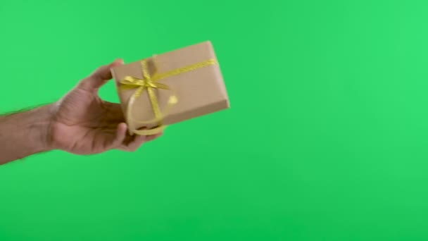 Mano masculina dando una caja de regalo a una mano femenina en el fondo de la pantalla verde de la tecla de croma. El concepto de la fiesta, regalos, cumpleaños, día de San Valentín. En cámara lenta. De cerca.. — Vídeos de Stock