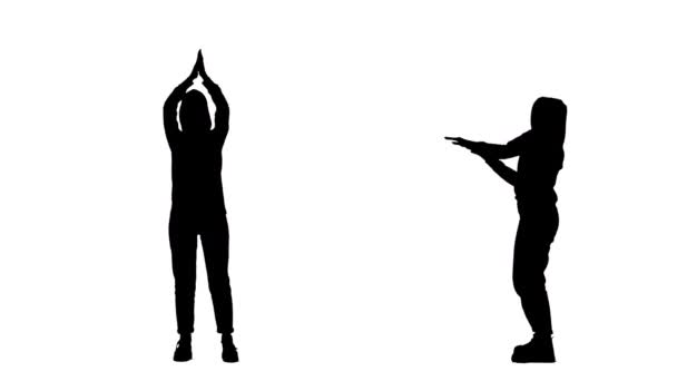 若いスタイリッシュな服の若い女性の黒いシルエットは、ディスコでモダンなダンスを踊っています。2で1コラージュフロントと白の背景に完全な長さを表示します。スローモーション準備59.94fps. — ストック動画