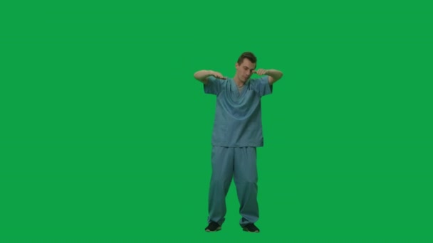 Портрет молодого человека в синем костюме врача-хирурга, танцующего и машущего руками. Полная длина на зеленом фоне экрана. Медленное движение готово, 4K на 59,94fps. — стоковое видео