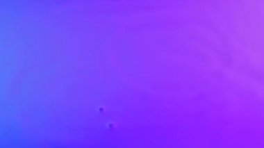 Güçlü titreşimler yukarı doğru pembe mavi renkli süt düşürür. Hızla değişen titreşimsel dalga yapıları rezonans yaratır ve süt sıvısının yüzeyine damlalar asılır. Ağır çekim. Kapat..