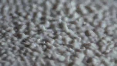 Beyaz sütün makro titreşimli küresel damlası. Güçlü titreşimler damlacıkları yukarı doğru kaldırır. Titreşen süt yüzeyinde yoğun sıçrama ve düşüş hareketleri. Ağır çekim. Kapat..