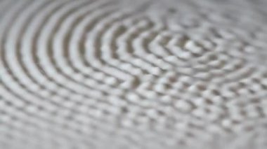 Düz beyaz süt yüzeyi hoparlörün frekansına titreşmeye başlar. Yapışkan süt sıvısı, dalgalar, daireler ve damlalar. Ağır çekim. Kapat..