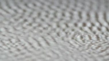 Sütün beyaz yüzeyinde simatik desenler oluşur. Sütlü sıvı ve akustik ses frekanslarını kullanarak doku oluşturma sanatı. Ağır çekim. Kapat..