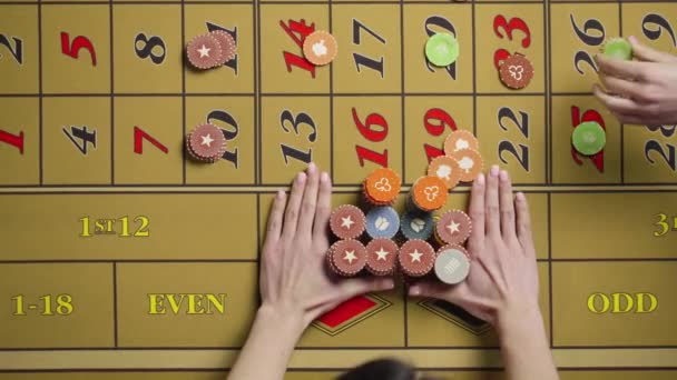 Hände von Männern und Frauen, die mit Chips auf einem Roulettetisch in einem Casino wetten. Die Wette gewinnt und der Dealer gibt den Gewinn an die glückliche Dame. Aus nächster Nähe. Zeitlupe bereit, 4K bei 59.94fps. — Stockvideo