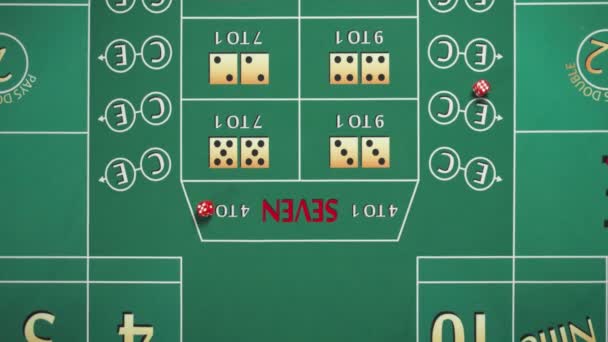 トップビューは、カジノでクラップをプレイするための緑のテーブルを閉じます。サイコロは数字5と1で表に落ちます。女の手がサイコロを振る。スローモーション. — ストック動画