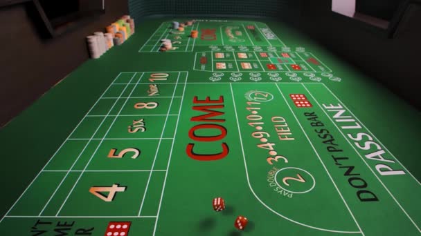 关闭绿桌，在赌场里玩垃圾游戏。红骰子落在桌子上,把薯片放好.赌博的商业概念。从游戏表的内部查看。慢动作. — 图库视频影像