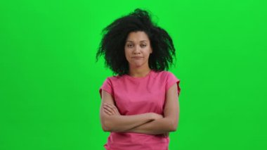 Genç dişi Afrikalı Amerikalı kızgın bir şekilde kafasını sallıyor hayır, sonra gülümsemeye başlıyor ve duyduklarına seviniyor ve el sallayarak evet diyor. Siyah kadın yeşil ekranda poz veriyor. Kapatın. Yavaş çekim hazır 59.97fps