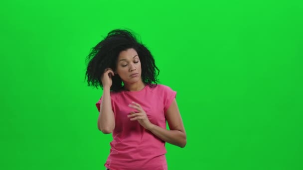 Ritratto di giovane donna afroamericana concentrata a pensare a qualcosa, non ne ho idea. Donna nera con i capelli ricci posa sullo schermo verde in studio. Chiudete. Rallentatore pronto 59.97 fps. — Video Stock